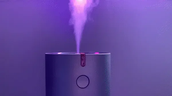 Primo piano dell’umidificatore EvenBreeze che rilascia un pennacchio di nebbiolina in luce viola