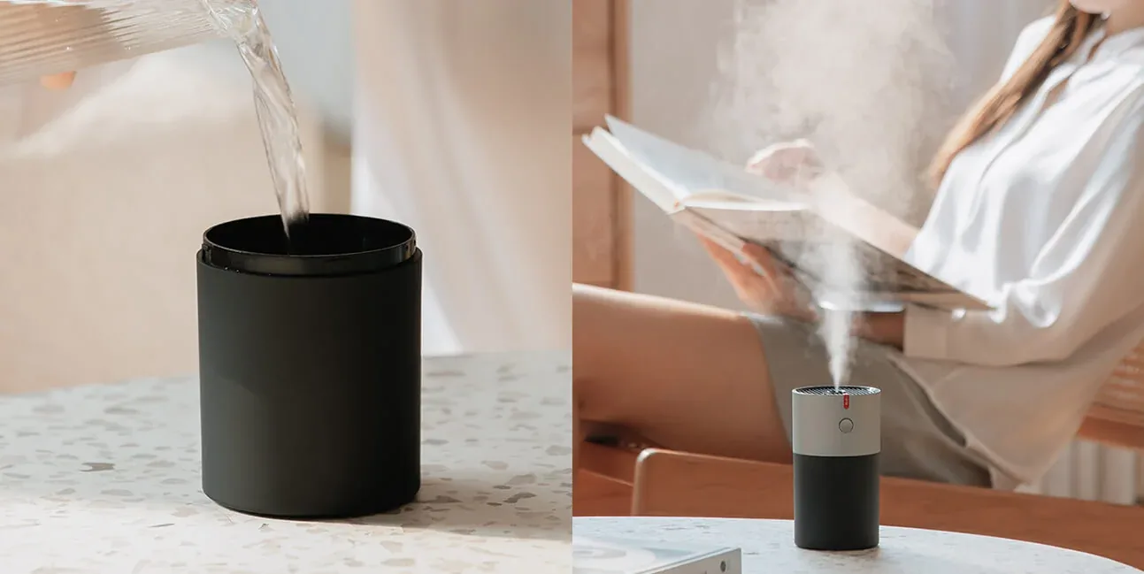 L’acqua versata nel serbatoio nero di EvenBreeze e l’umidificatore acceso accanto a una donna che legge un libro